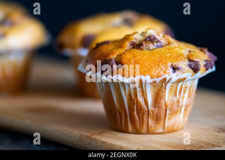 Freshly baked Chocolate Chip Muffins on a wooden platter Stock Photo
