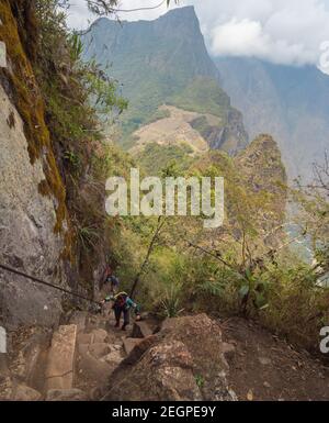 Peru, Machupicchu - September 26, 2019 - Tourist climbs up the steep stairs at Waynapicchu mountain trail Stock Photo