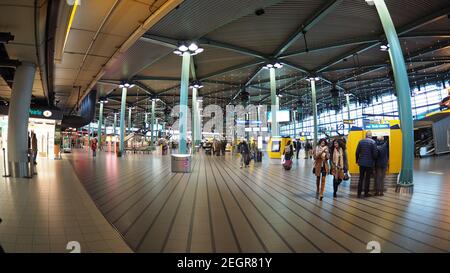 Amsterdam, Netherlands - December 6, 2017 - Amsterdam Schiphol Airport interior, travelers walk around main hall Stock Photo