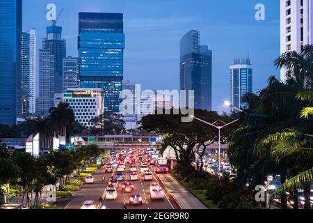 Jakarta, Indonesia - February 16 2021: Traffic captured with blurred motion rushes along the famous Sudirman avenue in the heart of Jakarta business d Stock Photo