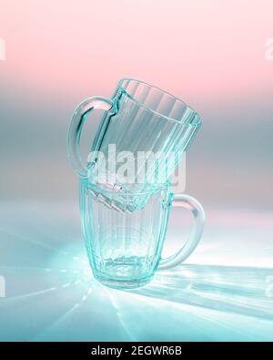 two empty beer glasses on table in blue and pink light Stock Photo