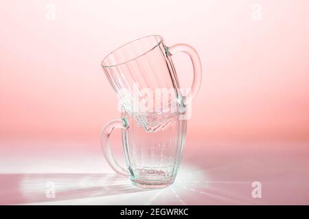 two empty beer glasses on table in pink light Stock Photo
