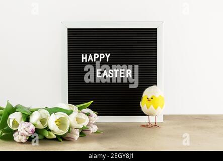 Happy Easter on letter board and tulips. Holiday concept Stock Photo