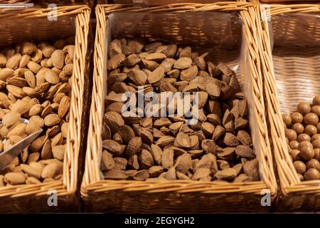 Unpacked Brazil nuts in nutshell in basket on display in organic super market Stock Photo