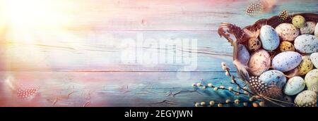 Easter Decoration - Rustic Eggs In Vintage Basket On Blue Table With Willows Branches And Feathers Stock Photo