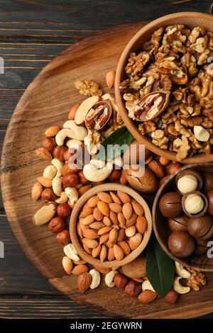 Tray with bowls with different nuts on wooden background Stock Photo