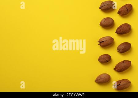 Tasty pecan nuts on yellow background, space for text and top view Stock Photo