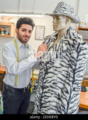 Schwedt, Germany. 16th Feb, 2021. Mojtaba Hosseiny, men's tailor at the Uckermärkische Bühnen Schwedt, stands next to a costume he designed for the revue "Linie 1". When Mojtaba Hosseiny fled Iran in 2015, he had only one goal, an education and a life with prospects. The 28-year-old has achieved both, thanks to many supporters in Schwedt and Berlin. Credit: Patrick Pleul/dpa-Zentralbild/ZB/dpa/Ģ����ý Live News Stock Photo