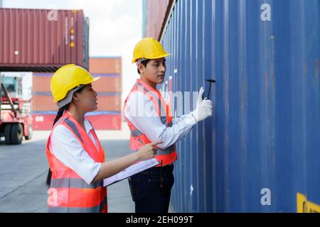 Asian engineer or Foreman using Chipping Hammer tool for checking the container after the repair complete to prepare the delivery to the customer. Stock Photo