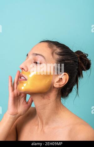 Beautiful woman using facial collagen gel skincare mask treatment Stock Photo