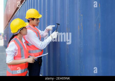 Asian engineer or Foreman using Chipping Hammer tool for checking the container after the repair complete to prepare the delivery to the customer. Stock Photo