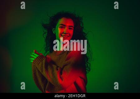 Contented. Caucasian woman's portrait isolated on green studio ...