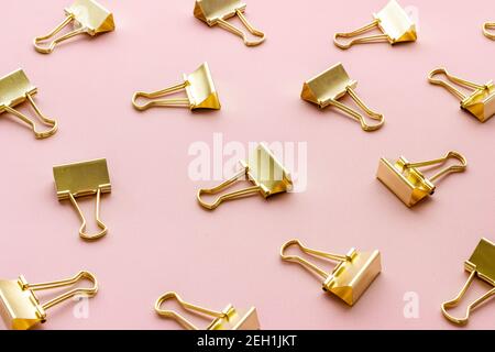 Office supplies pattern. Golden paper binder clips Stock Photo