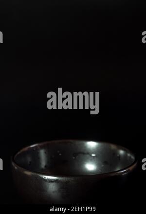 The low light shoot of the empty black bowl in black background Stock Photo