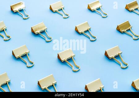Office supplies pattern. Golden paper binder clips Stock Photo