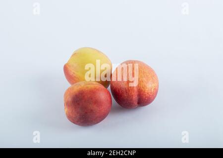 Three fresh nectarines on a white background Stock Photo