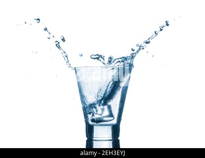 Water splash in glasses isolated on white background. Cold mineral water with ice in a glass. Stock Photo