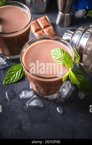Iced Chocolate cocktail. Summer refreshment drinks. Chilled iced chocolate coco drink, latte coffee. With ice, mint and chocolate slices on dark backg Stock Photo