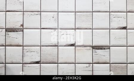 White aged tiles background. Seamless texture tiles. Old white small square dirty tiles on the wall Stock Photo