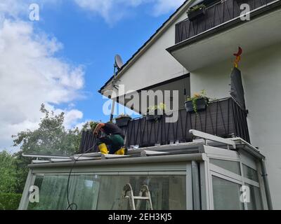 Man power washing conservatory roof and windows Stock Photo