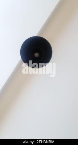 Black round ceiling chandelier or lamp hanging on white from the ceiling. Bottom view of a light bulb. Architectural decoration on the ceiling, hangin Stock Photo