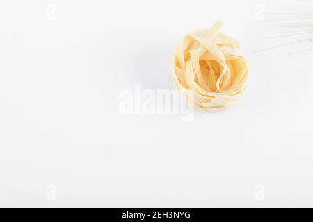 Three fettuccini pasta nests isolated on white background Stock Photo