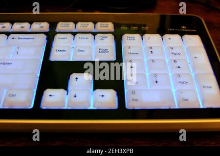 Top side view of an illuminated keyboard with black letters on white ...