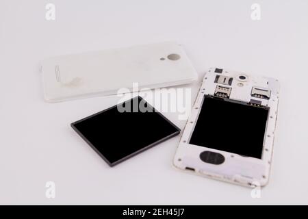 a smartphone with removed cover and battery on white background phone repair Stock Photo
