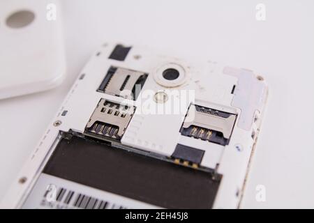 a smartphone with removed cover and battery on white background phone repair Stock Photo