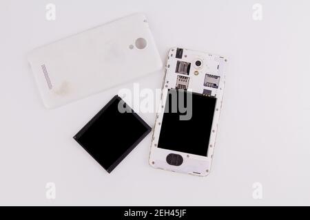 a smartphone with removed cover and battery on white background phone repair Stock Photo