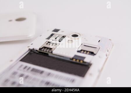 a smartphone with removed cover and battery on white background phone repair Stock Photo