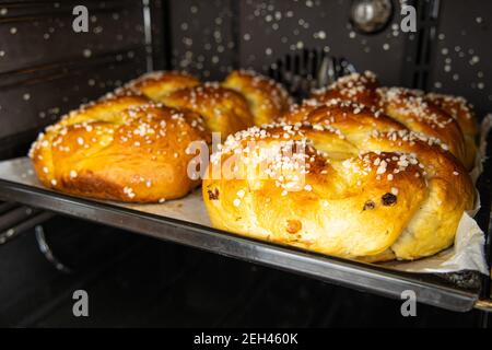 Typical traditional Austria: 2 Allerheiligenstriezel on a tin sheet and paper are finished in the open cooker Stock Photo