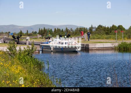 Young people on a boat going through a lock on the Forth and Clyde Canal at Carron nr Falkirk Stock Photo