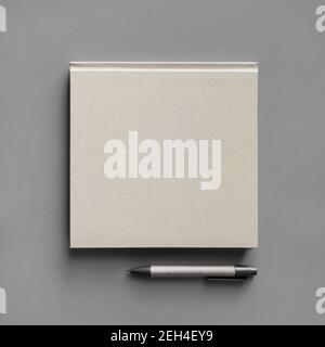 Blank square booklet and pencil on gray background. Template for branding design. Top view. Flat lay. Stock Photo