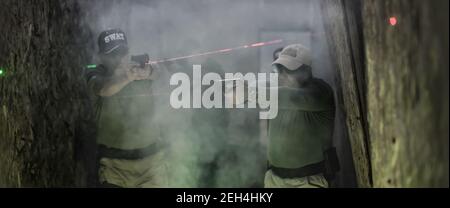 Army soldier in action aiming at weapon laser sight optics. Shooting and weapons. Outdoor shooting range Stock Photo