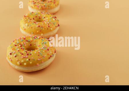 horizontal photo of doughnuts to the right on a pastel orange background with copy space Stock Photo