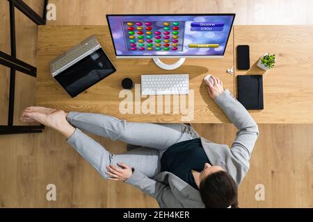 Lazy Woman Playing Game On Computer In Home Office Stock Photo