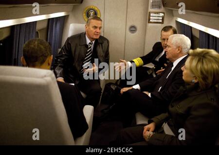 As President Barack Obama reads over his speech, his national security team confer aboard Marine One en route from the White House to Andrews Air Force Base.  From left, NSC Advisor Gen. James Jones, Admiral Michael Mullen, chairman of the Joint Chiefs of Staff, Defense Secretary Robert Gates, and Secretary of State Hillary Rodham Clinton. The President traveled to the U.S. Military Academy at West Point in West Point, N.Y., where he delivered a speech on his new Afghanistan policy Dec. 1, 2009. Stock Photo