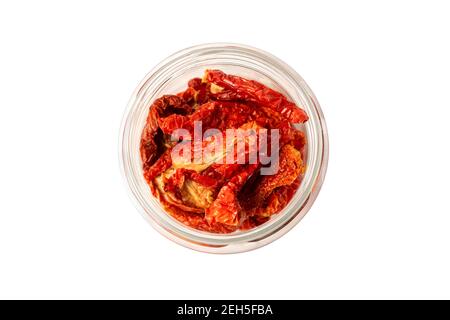 Italian sun-dried tomatoes close-up. Isolated image of sun-dried tomatoes in a glass jar on a white background. Stock Photo