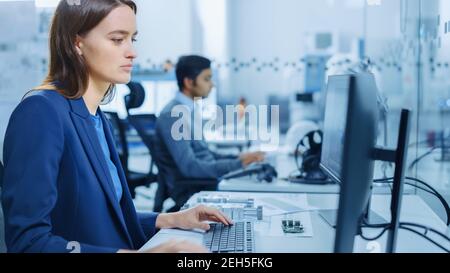 Portrait Shot of Mechanical Engineer Working on Personal Computers. Industrial Factory with High-Tech CNC Machinery Stock Photo