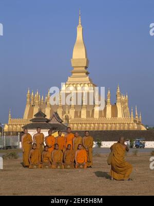 Asia,Laos, Vientiane, group of monks posing for souvenir photos in front of the Great sacred Buddhist  Stupa Pha That Luang Stock Photo