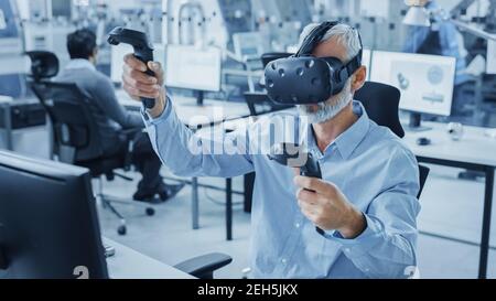 Industrial Design Engineer Wearing Virtual Reality Headset and Holding Controllers, Uses VR technology for Industrial Design, Development using Stock Photo