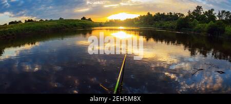 Beautiful summer sunset nature landscape.Distorted horizon. Tranquil evening scene with warm sunlight and amazing reflection of clods in sky on the wa Stock Photo