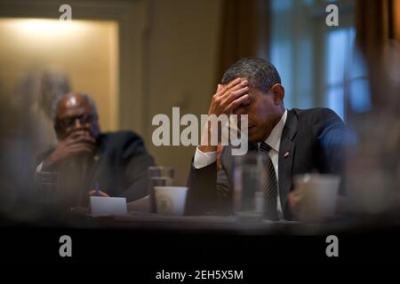 President Barack Obama pauses during a health care meeting with members of Congress in the Cabinet Room of the White House, Jan. 15, 2010. Rep. James Clyburn, D-S.C., is seated at left. Stock Photo