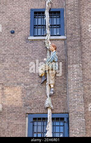 Deventer, The Netherlands - January 1, 2021: Girl climbing out of window on sheets from the Charles Dickens Mueseum in Deventer, The Netherlands Stock Photo