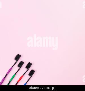 Eco tooth brushes made of biodegradable plastic and bamboo active charcoal bristle on pink background Stock Photo