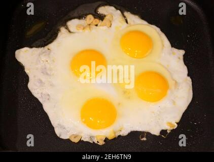Four egg yolks and white eggs on the top of the hot stove Stock Photo