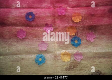 gradient colored transparent fabric covering colorful paper flowers Stock Photo