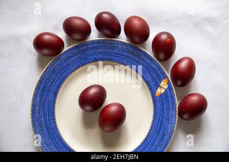 a table with Easter colored eggs on white table cloth Stock Photo