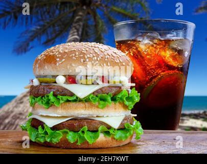 Double hamburger with soda cola on a beach in summer Stock Photo